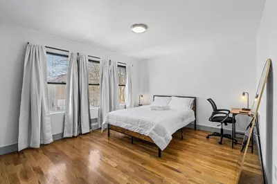 a white bedroom with a bed and a window at 3BR Apt Mins to Bus Newark Airport Penn Sta NYC in Hillside