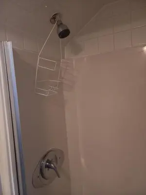 a shower with a light on the top of it at Cozy attic guest room in North Bergen