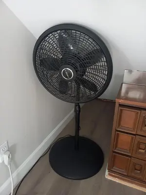 a black fan is sitting in a room at Cozy attic guest room in North Bergen