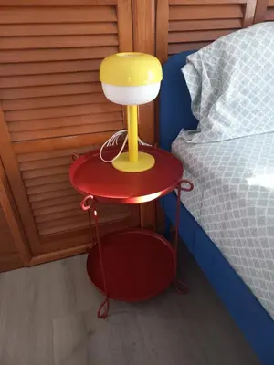 a table with a lamp on it next to a bed at Cozy attic guest room in North Bergen