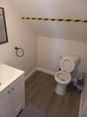 a bathroom with a toilet and a sink at Cozy attic guest room in North Bergen