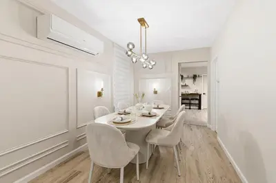 a white dining room with a white table and chairs at Near to Manhattan PATH Train To NYC EWR in Harrison