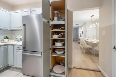 a kitchen with a refrigerator and a dining room at Near to Manhattan PATH Train To NYC EWR in Harrison