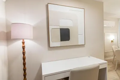 a white desk with a lamp and a picture on the wall at Near to Manhattan PATH Train To NYC EWR in Harrison