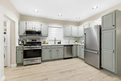 a kitchen with white cabinets and stainless steel appliances at Near to Manhattan PATH Train To NYC EWR in Harrison