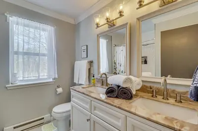a bathroom with a sink and a toilet and a mirror at Family Retreat with Game Room, 4 Mi to Kalahari! in Emerald Lakes