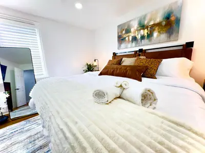 a bedroom with a large white bed with towels on it at Comfort Philly Stay Jacuzzi and Parking in Philadelphia