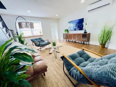 a living room with a couch and chairs and a tv at Comfort Philly Stay Jacuzzi and Parking in Philadelphia