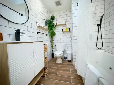 a bathroom with a toilet and a tub and a sink at Comfort Philly Stay Jacuzzi and Parking in Philadelphia