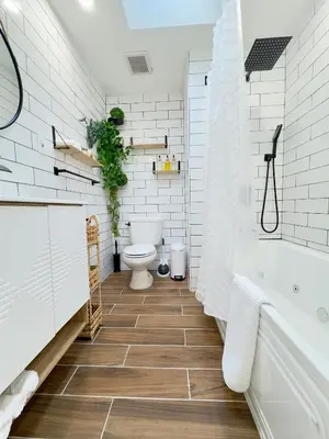a bathroom with a tub and a toilet and a sink at Comfort Philly Stay Jacuzzi and Parking in Philadelphia