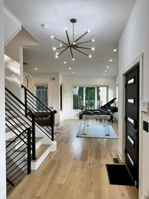 a living room with a staircase and a chandelier at Modern Lakeview Home with Private Dock Sleeps 5 in Landing