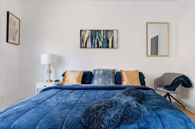 a bedroom with a blue bed and a chair at Modern Lakeview Home with Private Dock Sleeps 5 in Landing