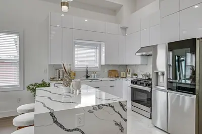 a kitchen with white cabinets and a marble counter top at 6 Mi to Manhattan Luxe Apt with City Views! in Jersey City