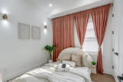 a bedroom with a white bed in front of a window at 6 Mi to Manhattan Luxe Apt with City Views! in Jersey City
