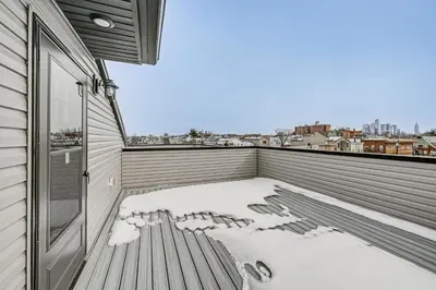 a snow covered balcony with a view of the city at 6 Mi to Manhattan Luxe Apt with City Views! in Jersey City