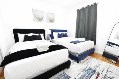 a bedroom with two beds and a rug at Manhattan Skyline Views Spacious 3BR in Jersey City