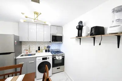 a kitchen with white cabinets and a stove top oven at Manhattan Skyline Views Spacious 3BR in Jersey City