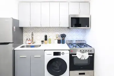 a kitchen with a stove and a washing machine at Manhattan Skyline Views Spacious 3BR in Jersey City