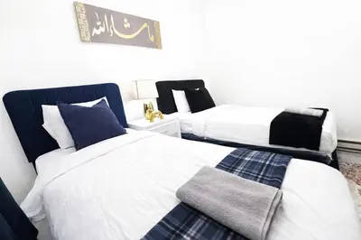 a bedroom with two beds and a blanket at Manhattan Skyline Views Spacious 3BR in Jersey City