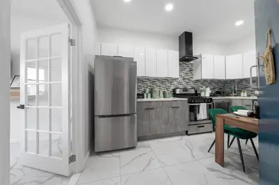 a kitchen with a stainless steel refrigerator and a table at 5 beds 7 person Prime Location Near Transit NYC in Jersey City