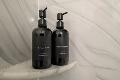 two black bottles sitting on a shelf in a bathroom at 5 beds 7 person Prime Location Near Transit NYC in Jersey City