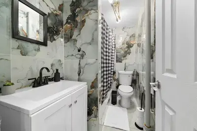 a bathroom with a white sink and a toilet at Spacious 3BR NYC Manhattan Skyline Views Nearby in West New York