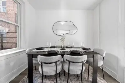 a dining room with a black table and chairs at Spacious 3BR NYC Manhattan Skyline Views Nearby in West New York