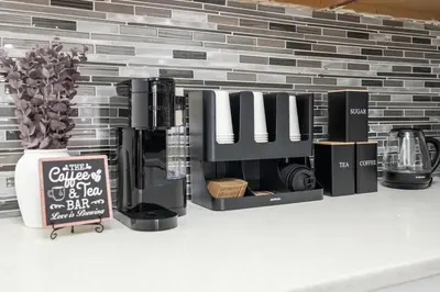 a coffee maker on a counter with a brick wall at Bright 4B - Full Kitchen -15 min to Mannhatan in Jersey City