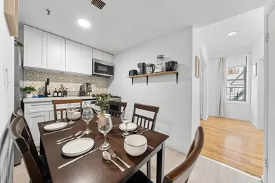 a kitchen and dining room with a table and chairs at Fast access to NYC - family & group -skyline view in Jersey City