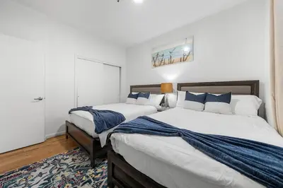 a bedroom with two beds with blue and white pillows at Fast access to NYC - family & group -skyline view in Jersey City