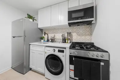 a kitchen with a washing machine and a refrigerator at Fast access to NYC - family & group -skyline view in Jersey City