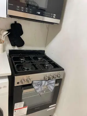 a stove in a kitchen with a microwave above it at 3-Bedroom 5-Beds JC Downtown 19Minutes Time Square in Jersey City