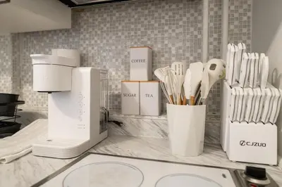 a kitchen counter with white utensils on it at Modern 2BR Apartment - 15 min to NYC - Sleeps 6 in West New York
