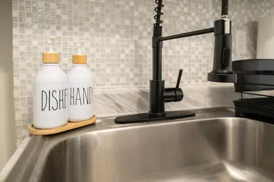 two bottles of detergent sitting on a kitchen sink at Modern 2BR Apartment - 15 min to NYC - Sleeps 6 in West New York