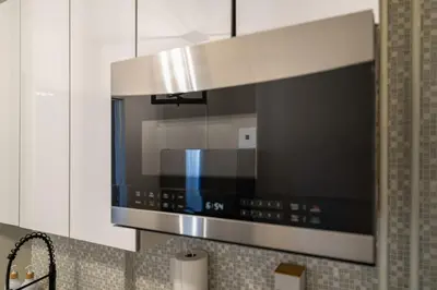 a kitchen with a stainless steel stove top oven at Modern 2BR Apartment - 15 min to NYC - Sleeps 6 in West New York