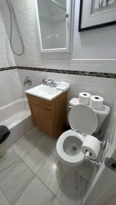 a bathroom with a toilet and a sink at Trendy 5-Bedroom Home in NYC Prime Location in New York