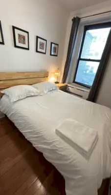 a white bed in a room with a window at Trendy 5-Bedroom Home in NYC Prime Location in New York
