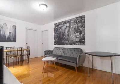 a living room with a couch and a table at 10th Avenue Urban Retreat- 3BR NYC in New York