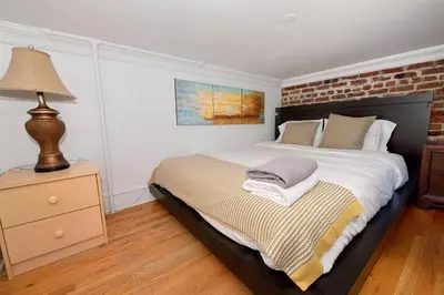 a bedroom with a bed and a brick wall at 10th Avenue Urban Retreat- 3BR NYC in New York
