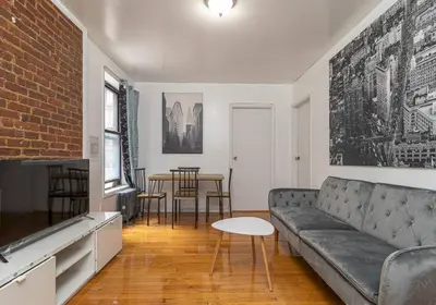 a living room with a couch and a table at 10th Avenue Urban Retreat- 3BR NYC in New York
