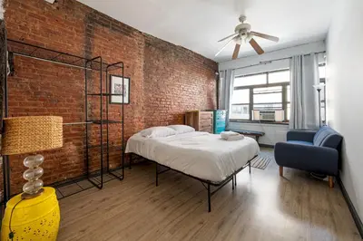 a bedroom with a bed and a brick wall at Prime NYC Stay- 3 BR Apartment in New York