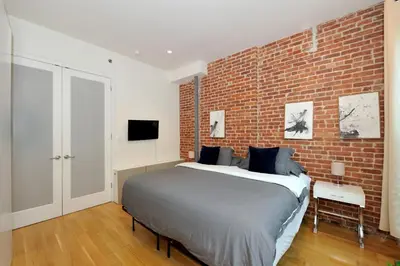 a bedroom with a bed and a brick wall at Time Square Vicinity- Luxury 2BR 2BA NYC Apt in New York