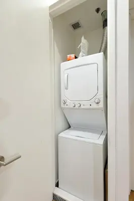 a washer and dryer in a small room with a refrigerator at Time Square Vicinity- Luxury 2BR 2BA NYC Apt in New York