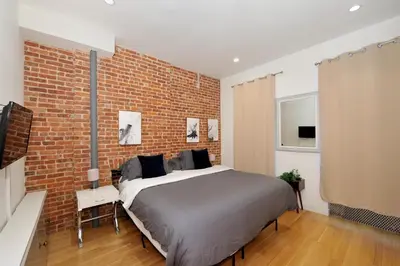 a bedroom with a large bed and a brick wall at Time Square Vicinity- Luxury 2BR 2BA NYC Apt in New York