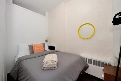 a bedroom with a bed with a mirror on the wall at Spacious Stay 3 BR in Prime Location of NYC in New York