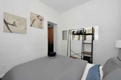 a bedroom with a bed and paintings on the wall at Spacious Stay 3 BR in Prime Location of NYC in New York