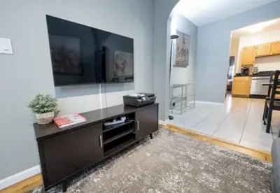 a living room with a large flat screen tv on a wall at Spacious Stay 3 BR in Prime Location of NYC in New York