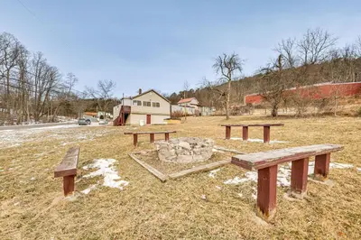 a group of benches sitting in a field at Group Getaway with Fire Pit Near Susquehanna River! in Danville