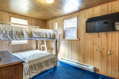 a bedroom with a bunk bed and a flat screen tv at Group Getaway with Fire Pit Near Susquehanna River! in Danville