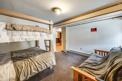 a room with two bunk beds and a couch at Group Getaway with Fire Pit Near Susquehanna River! in Danville